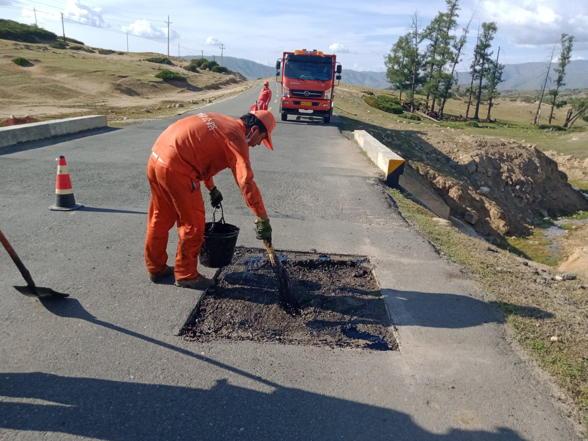 哈巴河公路管理分局职周俊强工在撒布底油 图：赛力克别克·阿伟太.jpg