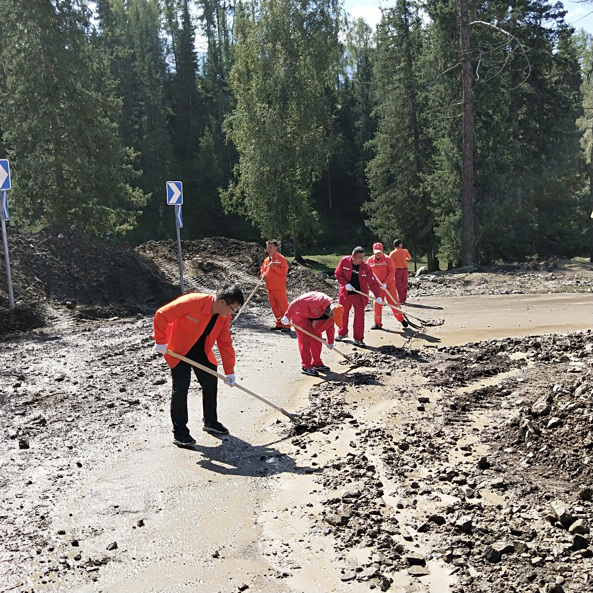 哈巴河公路管理党组书记、副局长李翔，副书记沈军带头清理路面泥石流中 图：许立全.jpg