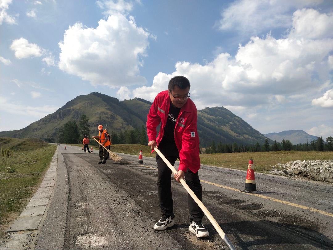 哈巴河公路管理分局党组书记、副局长李翔清理铣刨路面废料中 图：苏玮.jpg