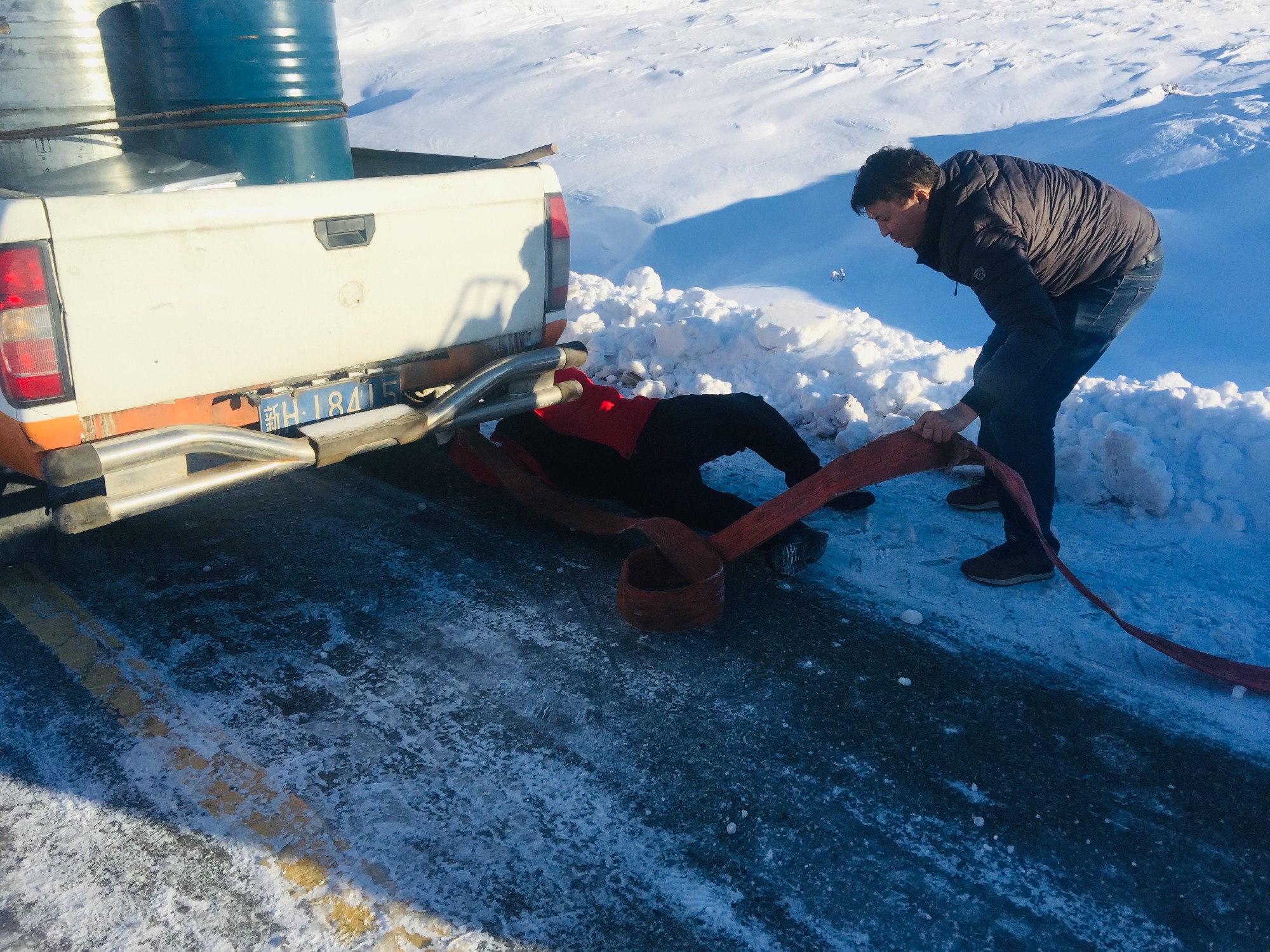 哈巴河公路管理分局冬季除雪保通队员在2车之间悬挂拖车绳  图：叶什波·海拉什.jpg