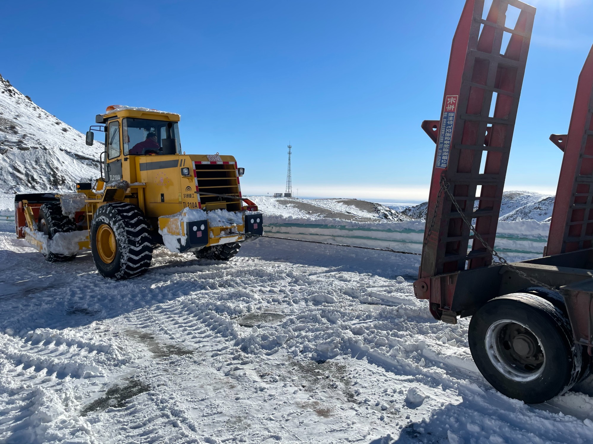 哈巴河公路管理分局轮式推雪机拽重型货车  图：蒋磊.jpg