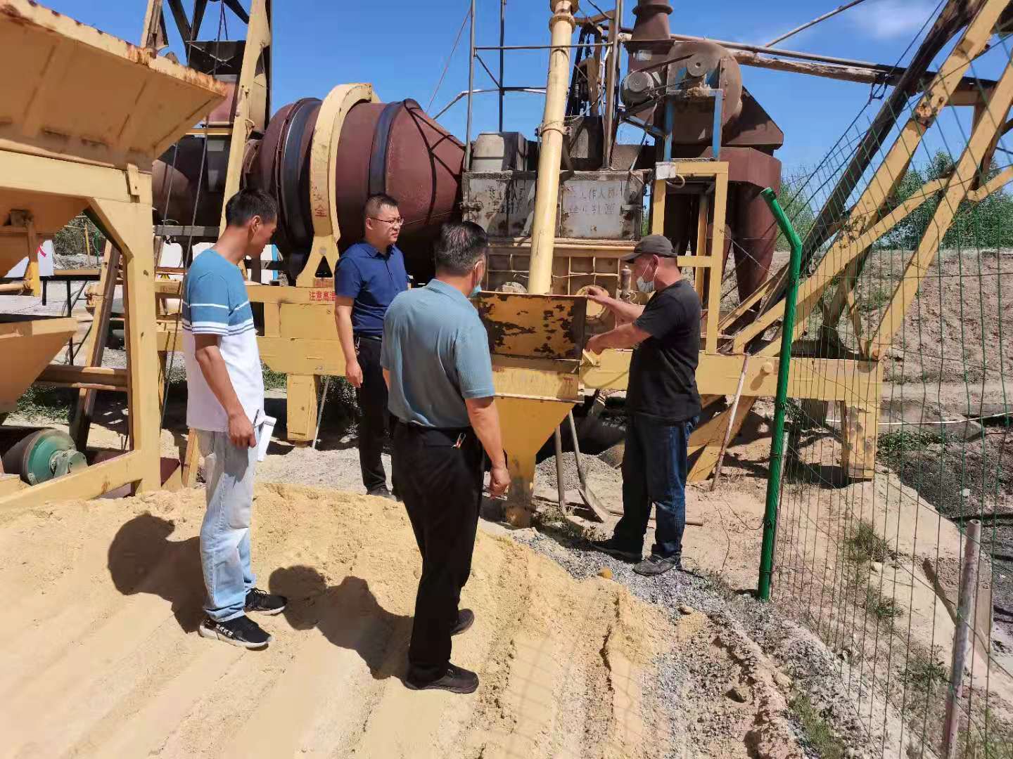 拌合站站长张恒在给检查组介绍拌合站相关设施  图：加尔肯•达布勒.jpg